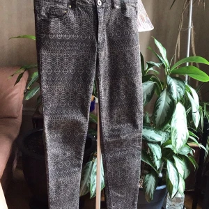 Mönstrade byxor från H&M - Snygga byxor från H&M med ett unikt geometriskt mönster i grått och svart. Byxorna har en knapp och dragkedja framtill samt fickor bak. Perfekta för att ge din outfit en cool touch.