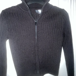 Svart ribbad kofta med dragkedja - Snygg svart ribbad kofta med dragkedja framtill. Nyskick