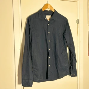 Mörkblå linnebled skjorta  - Snygg mörkblå skjorta med klassisk krage och knappar hela vägen ner. Perfekt för en stilren look. Långärmad och tillverkad i ett bekvämt material.