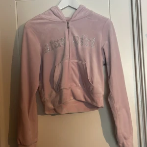 Rosa hoodie från FB Sister - Säljer en rosa hoodie från FB Sister med texten 'star girl' i glittriga stenar på framsidan. Tröjan har en dragkedja och en stor ficka framtill. Perfekt för en avslappnad stil.