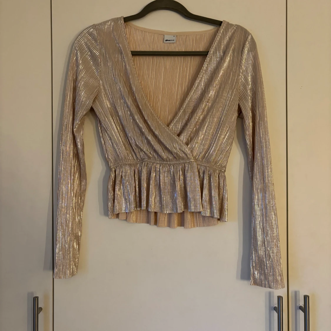 Glittrig beige omlottopp från Gina Tricot