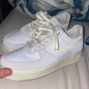 Beige Nike Air Force sneakers - Säljer ett par beige Nike Air Force sneakers. De har en stilren design med snörning och en robust sula. Perfekta för en casual look.