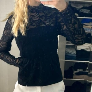 Svart spetsblus från Bik Bok - Säljer en elegant svart spetsblus från Bik Bok i storlek XS. Blusen har långa ärmar och ett vackert spetsmönster som ger en stilren look. Perfekt för att lyfta vilken outfit som helst.