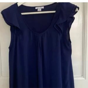 Mörkblå ärmlös blus  - Säljer en mörkblå blus från New yorker. Den är ärmlös med volangdetaljer vid axlarna och har en v-ringad form💕