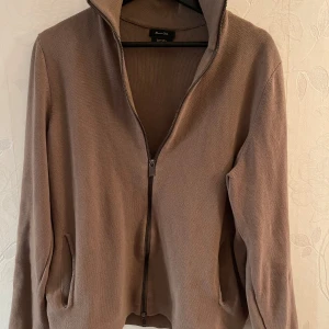 Beige tröja med dragkedja från Massimo Dutti - Säljer en stilren beige tröja från Massimo Dutti med dragkedja framtill. Tröjan har en hög krage och långa ärmar, perfekt för en avslappnad men elegant look. Passar bra till både jeans och chinos. Skicket är 10/10, knappt använd. 😀 