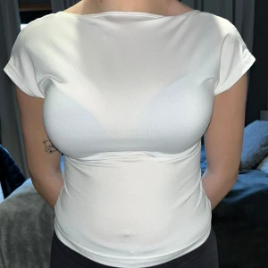 Vit topp med öppen rygg - Säljer en vit topp med korta ärmar och en snygg öppen rygg. 