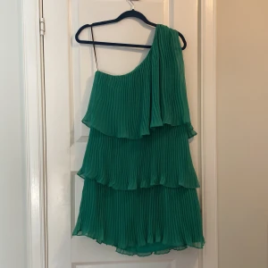 Grön One shoulder klänning från Zara! Nyskick!  - Snygg grön plisserad klänning med oneshoulder-design. Perfekt för en somrig look med sina volanger som ger extra stil. Klänningen har en luftig och lätt känsla. Intresserad? Fler bilder finns!  Kolla gärna i byxorna från Zara nya med prislappar som jag la upp igår! Nästan samma färg som denna klänning! Supersnygga! 
