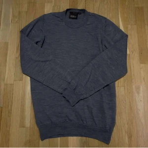 Grå tröja från Oscar Jacobson - Säljer en stilren grå tröja från Oscar Jacobson. Tröjan är tillverkad i merinoull  som gör den väldigt bekväm. Kom privat vid fler funderingar🙌