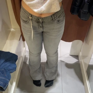 Grå bootcut jeans - Gråa bootcut jeans ifrån Gina Tricot. De har lite slitage nere vid häken då de är lite för långa för mej, använd få ggr. Strl 44 