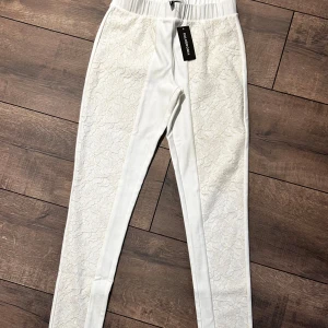 Vita leggings med spetsdetaljer från Calzedonia - Snygga vita leggings från Calzedonia med vackra spetsdetaljer längs benen och på bakfickorna. I storlek s men skulle säga att det är mer som xs 