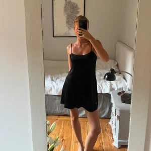 Svart kort klänning från Zara - Supersnygg svart klänning från Zara med tunna axelband och lätt glansigt tyg. Perfekt som festklänning. 