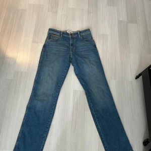 Wrangler Texas blå jeans W31 L34 - Säljer ett par klassiska Wrangler Texas jeans i blå tvätt. De har rak passform, normal midja. Jeansen är tillverkade i slitstarkt bomullsmaterial och har snygga kontrastsömmar. Perfekta för dig som gillar tidlös denimstil.