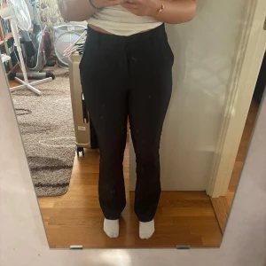 Svarta bootcut kostymbyxor BikBok - Snygga svarta kostymbyxor från BikBok i storlek 36. Byxorna har bootcut passform med hög midja och klassisk rak siluett. Perfekta till en clean och stilren look, med diskreta fickor och knappstängning framtill. Säljer då jag har köpt nya. 