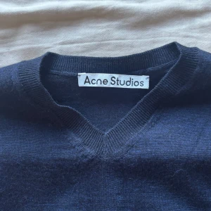 Mörkblå v-ringad tröja Acne Studios - Marinblå stickad tröja från Acne studios. Herrstorlek. Regular size. 100% ull