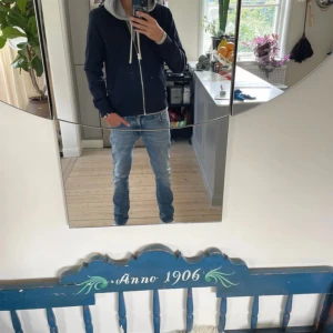 Marinblå jacka med dragkedja från elvine - Marinblå jacka från Elvine med hel dragkedja framtill och två fickor. Jackan har långa ärmar, ribbade muddar och en huva med blå insida . Perfekt för chill dagar och enkel att matcha med jeans eller joggers.