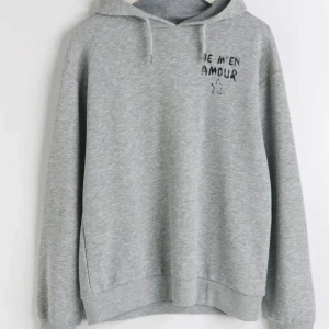 Grå hoodie med tryck - Säljer en slutsåld ljusgrå hoodie med svart texttryck från Gina i storlek 158/164 men sitter som en xs-S. Tröjan har huva med snörning och långa ärmar. Använd få gånger och är i bra skick💕