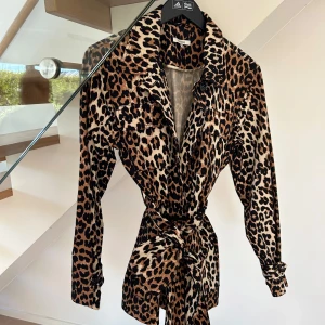 Leopardmönstrad kappa/jacka från Ganni - Säljer en snygg leopardmönstrad kappa/jacka från Ganni med lång ärm och knyt i midjan. 