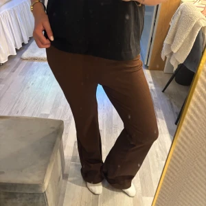 Bruna ribbade bootcut-byxor H&M - Säljer ett par bruna ribbade bootcut-byxor med glitter detaljer från Divided by H&M i storlek M. Byxorna har en skön stretchig passform och är tillverkade i polyesterblandning 🤩🤩