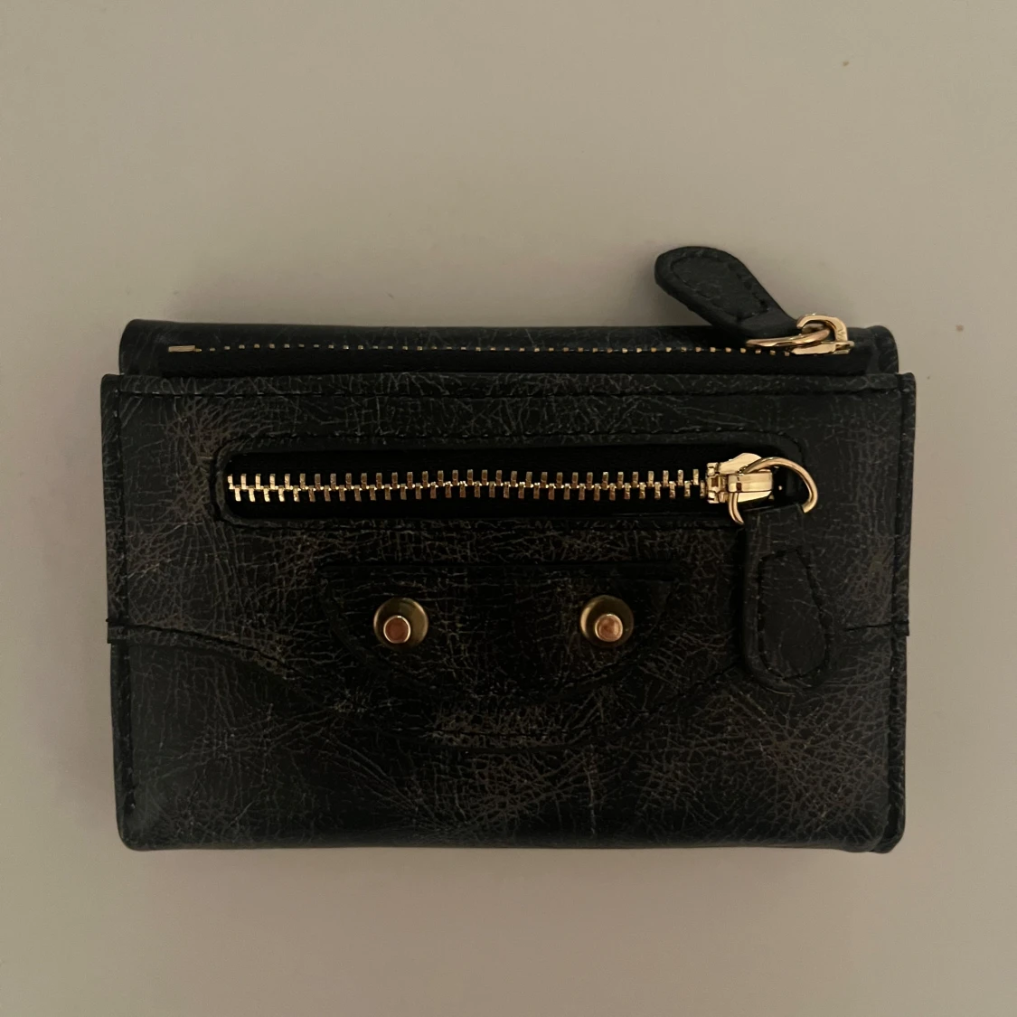 Svart plånbok med gulddetaljer