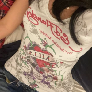 Ed Hardy vit t-shirt med tryck - Säljer en vit Ed Hardy t-shirt med coolt tryck framtill: dödskalle, hjärta och texten 'Love Kills'. T-shirten har v-ringning, korta ärmar och figurnära passform. Märket syns även på ryggen. Materialet är mjuk bomull, perfekt till jeans eller shorts. Pris går att diskutera 