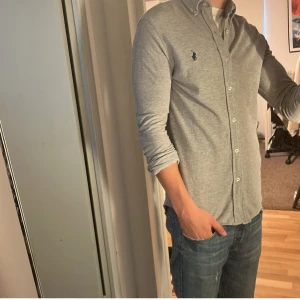 Ralph Lauren skjorta - Tja säljer en Ralph lauren skjorta i färgen grå och i storlek S. Nypris 1595 KR mitt pris 299 KR. Inga defekter som hål eller fläckar. Skriv vid frågor eller funderingar.