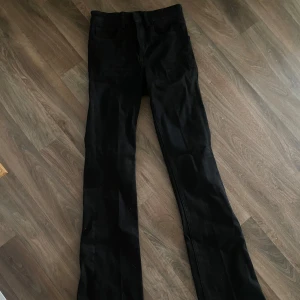Svarta bootcut jeans - Snygga svarta jeans med bootcut passform och klassisk femficksdesign. Jeansen har bälteshällor och är tillverkade i ett stretchigt jeansmaterial som sitter skönt. Perfekta för dig som gillar en tidlös look med lite utsvängda ben. Använda en gång 