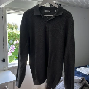 Grå ribbad pikétröja Only & Sons - Säljer en stilren grå pikétröja från Only & Sons i storlek L. Tröjan är ribbad, har lång ärm och klassisk krage med knappar framtill. Perfekt för dig som gillar en chill och clean look. Materialet är mjukt och känns skönt mot huden.