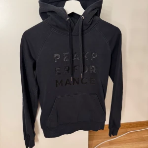 Svart hoodie Peak Performance XS - Svart hoodie från Peak Performance i storlek XS. 