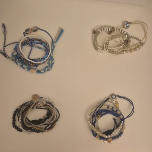 Färgglada pärlarmband med berlocker - Säljer fyra olika armband med pärlor i blått, vitt, svart, guld och silver. Varje armband har coola berlocker som ögon och hamsa-händer, samt detaljer som knytning och flätade band. Perfekt för dig som gillar att mixa och matcha smycken med personlig stil. 20 kr per styck