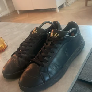 Svarta Polo Ralph Lauren sneakers - Snygga svarta sneakers från Polo Ralph Lauren. Gott skick och snyggt svart polo märke på utsidan. Perfekta till hösten