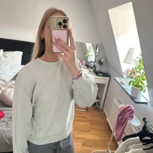  Turkos sweatshirt  - Grön blå sweatshirt med tryck bak från Gina Tricot. Ser ut som den är sliten men trycket ska se lite slitet ut. Använt ett par gånger och den är i ett fint skick. Normal i storleken. Skriv vid frågor eller om du är intresserad!💕