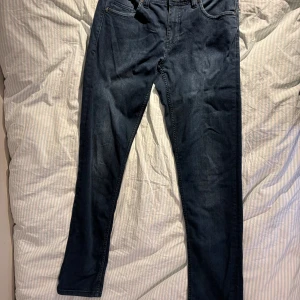 Mörkblå jeans från Bison W31 L34 - Snygga mörkblå jeans från Bison med klassisk femficksdesign och raka ben. Jeansen är stretchiga och en normal passform. Inga synliga defekter. Obs köparen betalar frakten