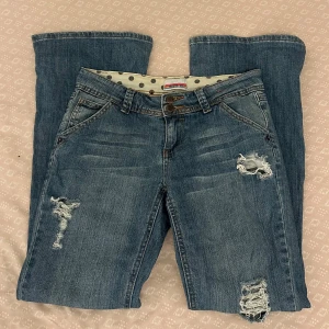 Lågmidjade bootcut jeans med slitningar - Köpta på Karlaplanloppis, hålen gjorde jag själv, har använt de 2 gånger. Säljer för de är för små för mig😊