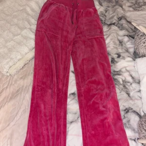 Rosa Juicy Couture  - Säljer dessa rosa Juicy Couture för dom inte kommer till användning längre, strl xxs, ena knappen har lossnat från hålet där den sitter men den delen av knappen sitter fortfarande på så de går enkelkt att sy på! Lite smustiga där nere men borde gå bort i tvätten, pris kan diskuteras!