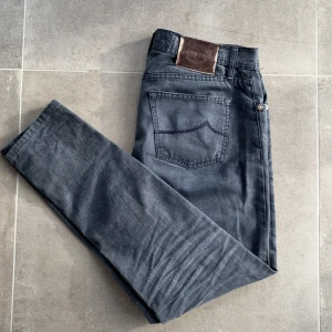 Jacob Cohen jeans - Gråa Jacob Cohen jeans i storlek 34 men sitter som 32, skick: 8/10, liten defekt på lappen bak(bild 4) annars jättefina, nypris 5000kr, mitt pris 950!