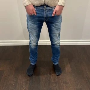 Blå replay jeans med ljusa tvättade detaljer - Snygga blå jeans ljusa tvättade detaljer på låren och knäna. De har en slim passform och är perfekta för en avslappnad stil. Dragkedja och knapp framtill. Säljer eftersom de inte längre kommer till användning. Priset som är 599 kan diskuteras.