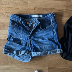 Blå jeansshorts från Amisu - Säljer ett par snygga blå jeansshorts från Amisu. De har en klassisk design med upprullade benslut och knappgylf. Perfekta för sommardagar!