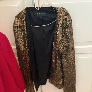Guldglittrig kavaj från Stockh LM - Finns att hämta på Kungsholmen. Säljer en glittrig kavaj i guld från Stockh LM. Perfekt för att sticka ut på festen! 