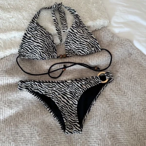 Zebra bikini - Såå söt zebramönstrad bikini! Överdelen är en L och underdelen är S. Funkar även om man har mindre byst, knyts själv i rygg&nacke så överdelen passar de flesta🧡🧡