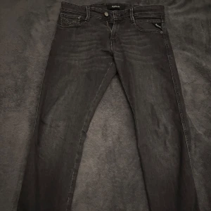 Svarta jeans från Replay - Snygga svarta jeans från Replay, modell Anbass. De har en slim fit och är perfekta för en stilren look. Klassisk femficksdesign med dragkedja och knapp. Passar bra till både vardag och mer uppklädda tillfällen.