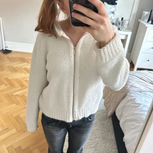 Vit hoodie med dragkedja  - Säljer en mysig och fin vit hoodie från Lindex i återvunnen polyester. Den har en dragkedja framtill och en skön huva. Pris kan diskuteras vid snabb affär😊