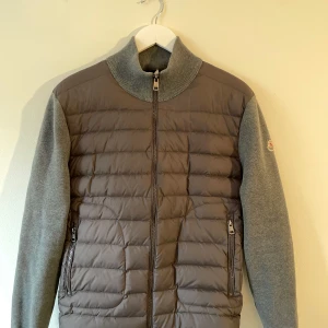 Grå cardigan jacka från Moncler - Tja! Säljer nu min älskade Moncler cardigan som är väldigt stilig och bra under våren och kalla sommar kvällar om du e sugen på o köpa eller har några frågor tveka inte på o höra av dig! Skick 9/10!