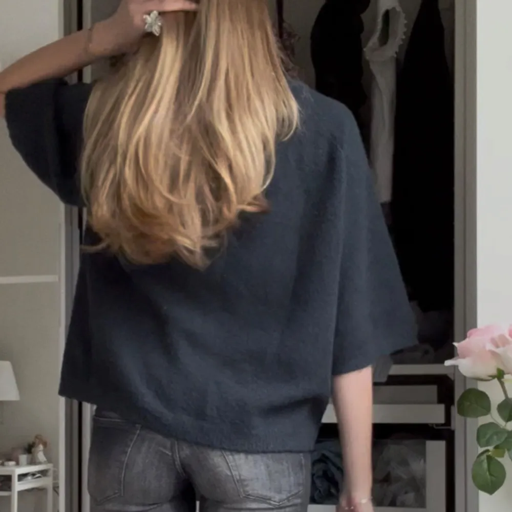 Säljer en stilren mörkblå tröja med trekvartsärm. Tröjan har en lös passform och är perfekt för en avslappnad look. Den är enkel att matcha med olika outfits och passar bra till både jeans och kjol.. Neuletakit & Villapaidat.