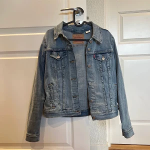 Blå jeansjacka från Levi's - Säljer en klassisk blå jeansjacka från Levi's. Jackan har en normal passform med knappar framtill i storlek M. Väldigt bra skick 