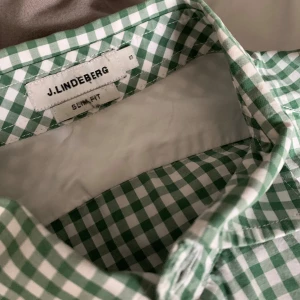 Grön J.Lindeberg skjorta - Snygg grön och vit rutig skjorta från J.Lindeberg i slim fit. Skjortan har långa ärmar och knappar framtill. Perfekt för en stilren look.