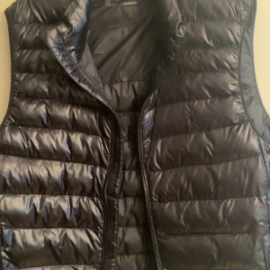 Svart väst från Polo Ralph Lauren - Snygg svart dunväst från Polo Ralph Lauren. Den är köpt från Zalando för ungefär 2500kr på rea och säljer den nu för jag tycker att jag själv inte passa i en väst så har använt den 3-4 gånger. Priset är inte fast kan dras ner