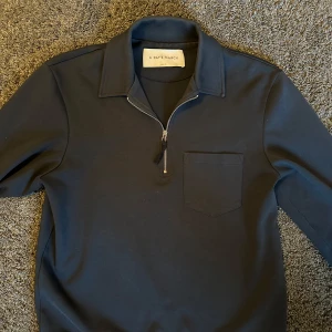 Halfzip från A Day's March - Snygg mörkblå halfzip från A Day's March. Inga tecken alls på användning typ, säljes för att den inte passar mig längre. Riktigt skön och fet färg på sommaren!