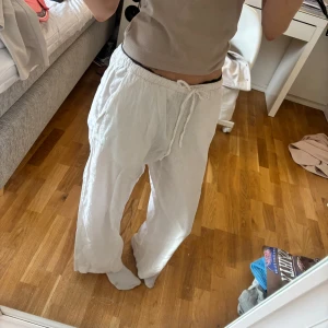 Vita linnebyxor med snörning - Säljer ett par vita linnebyxor med snörning i midjan. Byxorna har en loose fit och är perfekta för varma dagar. Från gina premium collection