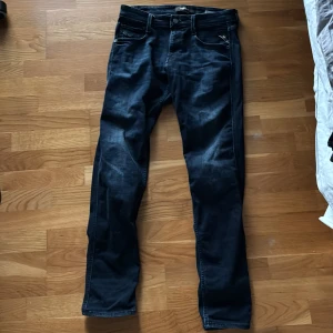 Mörkblå jeansbyxor - Snygga mörkblå jeansbyxor med en klassisk femficksdesign. Byxorna har en rak passform och är perfekta för en avslappnad stil. De har en knappgylf och bälteshällor för extra funktionalitet. Från Replay