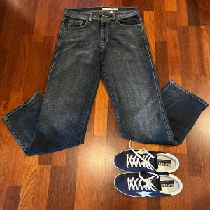 Laidback mörkblå DKNY jeans - Säljer nu dessa otroligt snygga laidback mörkblå jeansbyxor med klassisk femficksdesign och dragkedja. Perfekta för en avslappnad stil. Passar nog perfekt för dig som är kring 185 cm lång. Storleken är W32 och passformen är straight fit. Fraktar oftast samma dag 🚚(OBS: skorna ingår ej och är endast med i demonstrerande syfte)